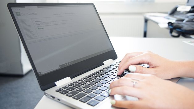 Hände die auf einer Laptoptastatur tippen